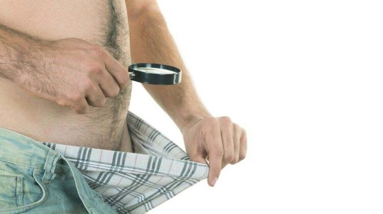een man kijkt in zijn onderbroek en denkt aan penisvergroting met frisdrank